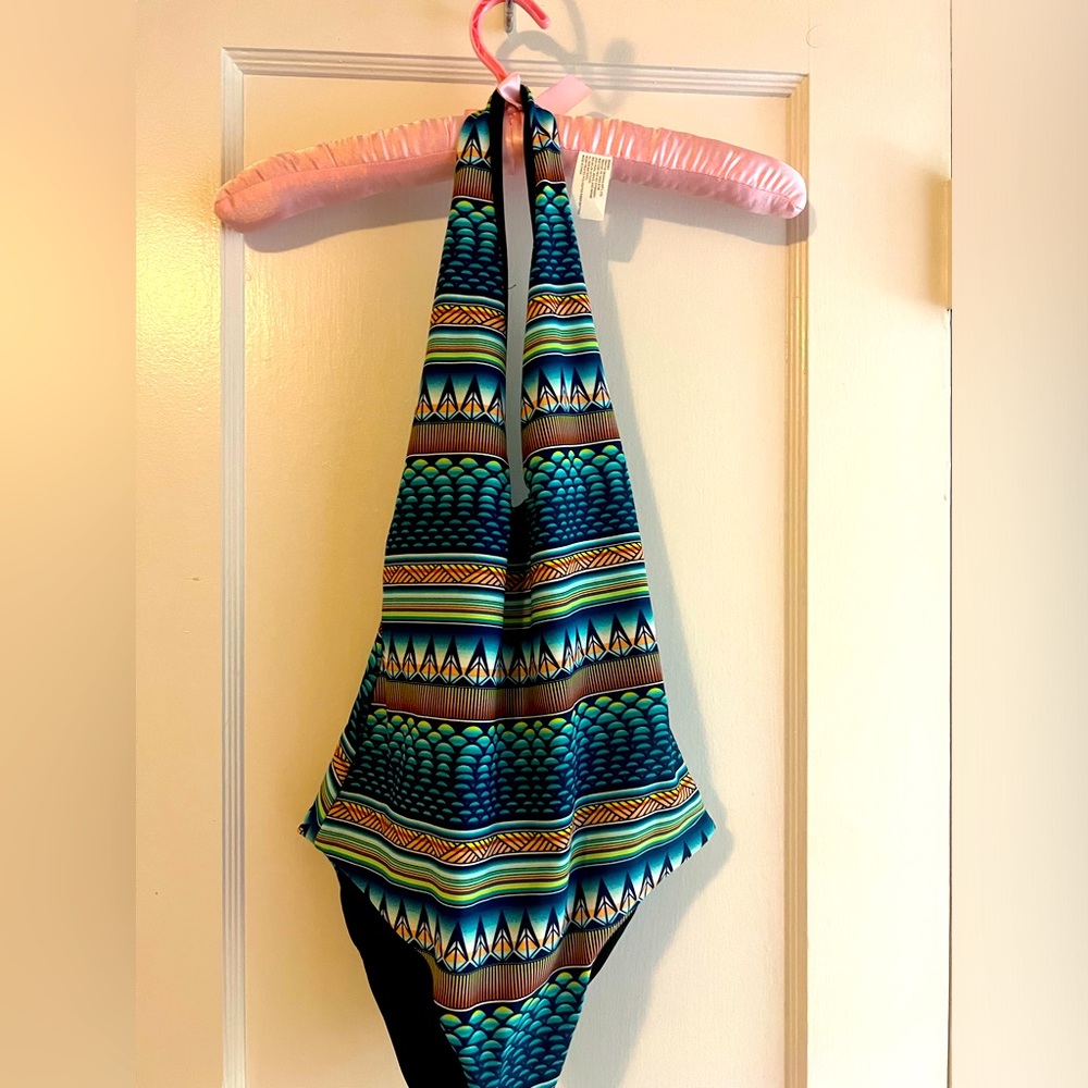 One piece swim suit deep cut neckline in front. Black lining. New no tags